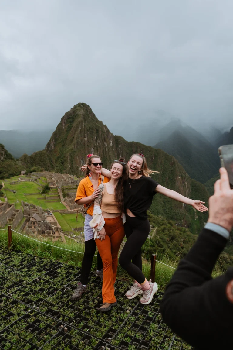 Friends taking a selfie with the Machu Picchu ruins in the background